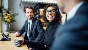 Group of three business people sitting at a coffee shop
