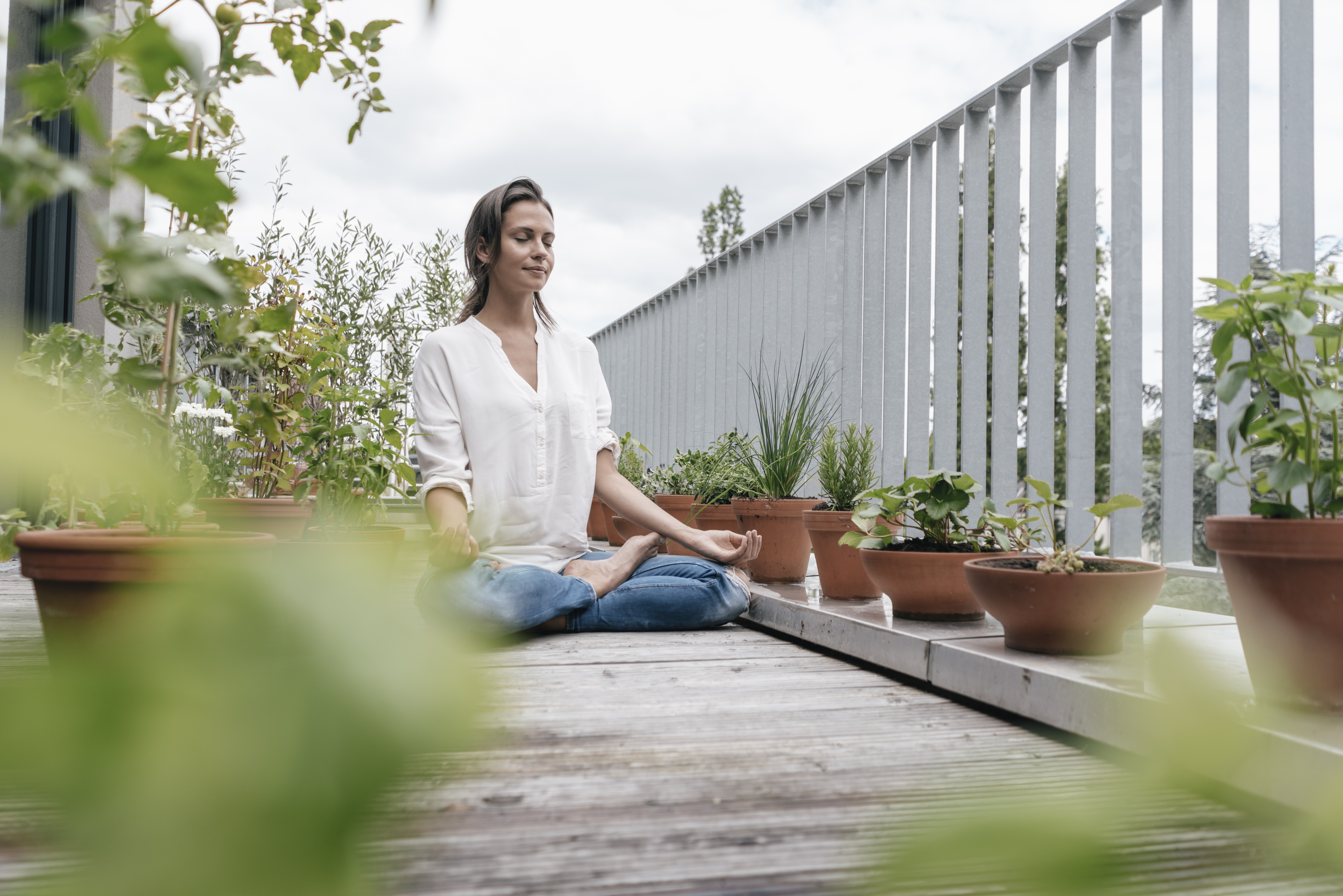 Woman sitting on balcony practicing yoga